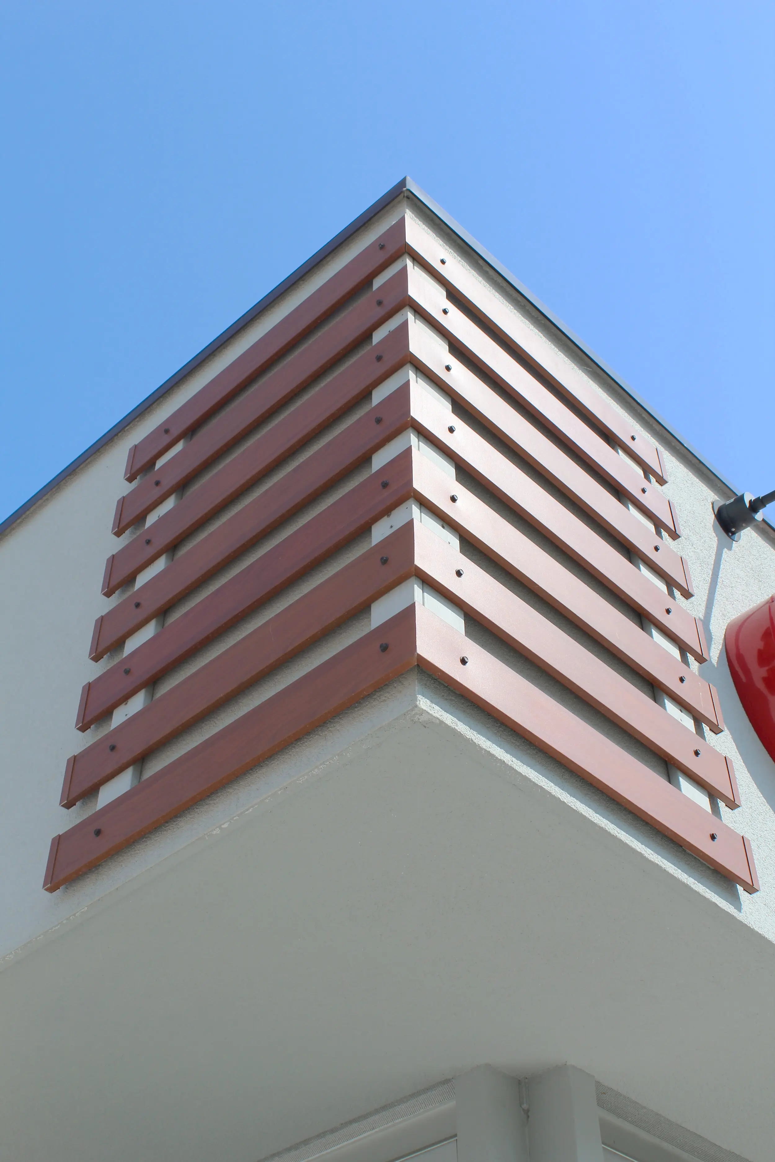 Corner of a commercial building wrapped in AFX woodgrain aluminum slats