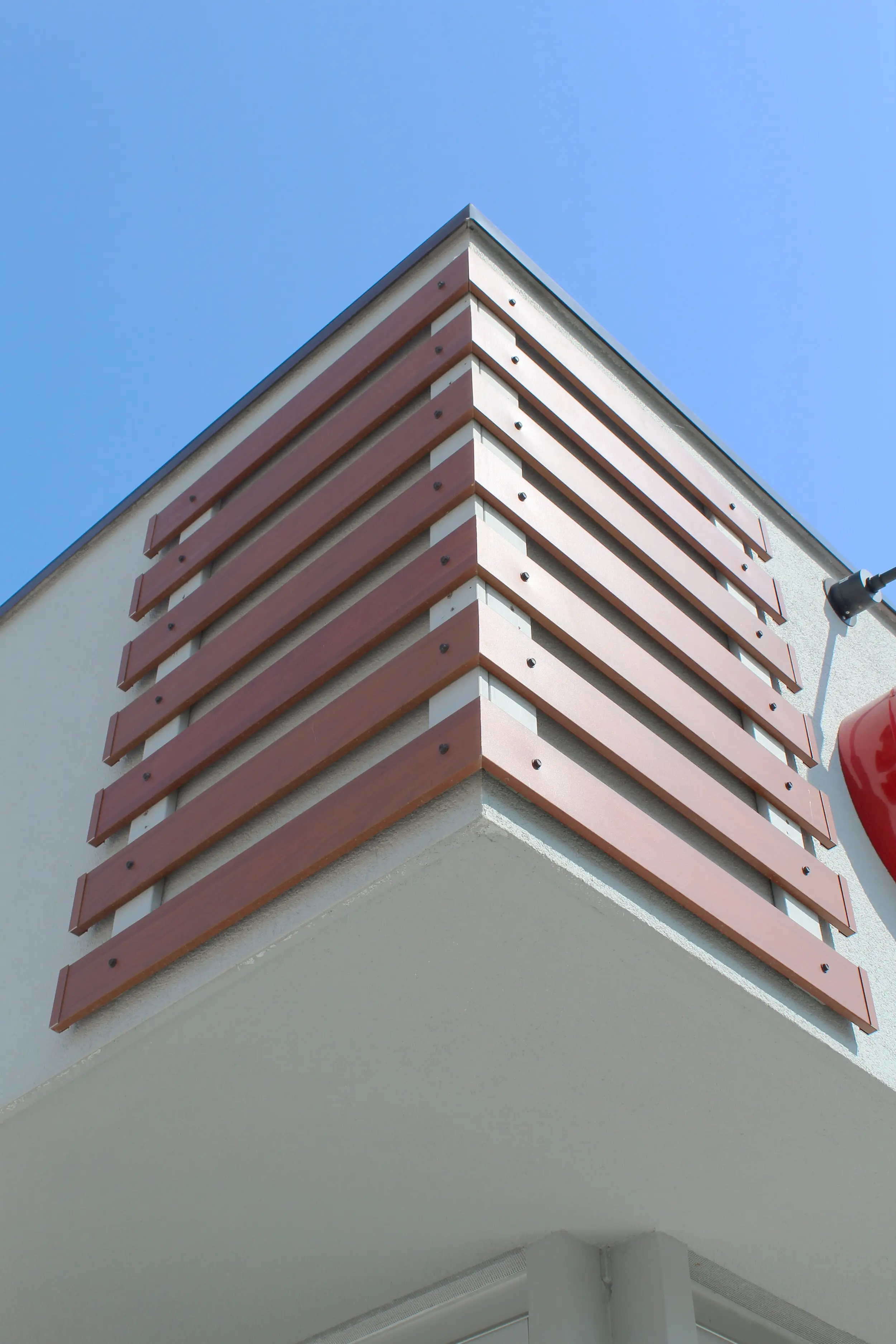 Corner of a commercial building wrapped in AFX woodgrain aluminum slats