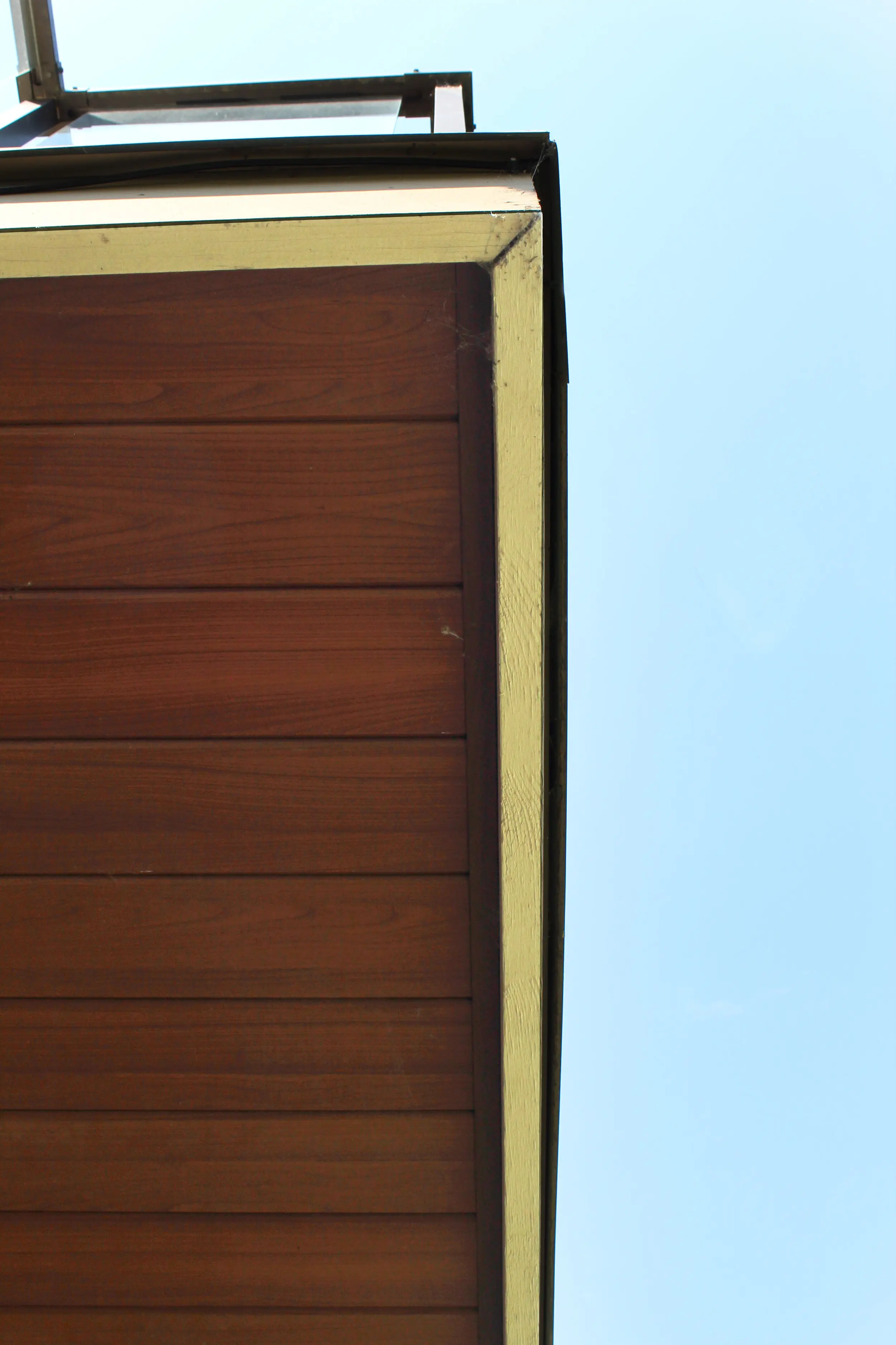 AFX woodgrain aluminum corner trim against a clear sky