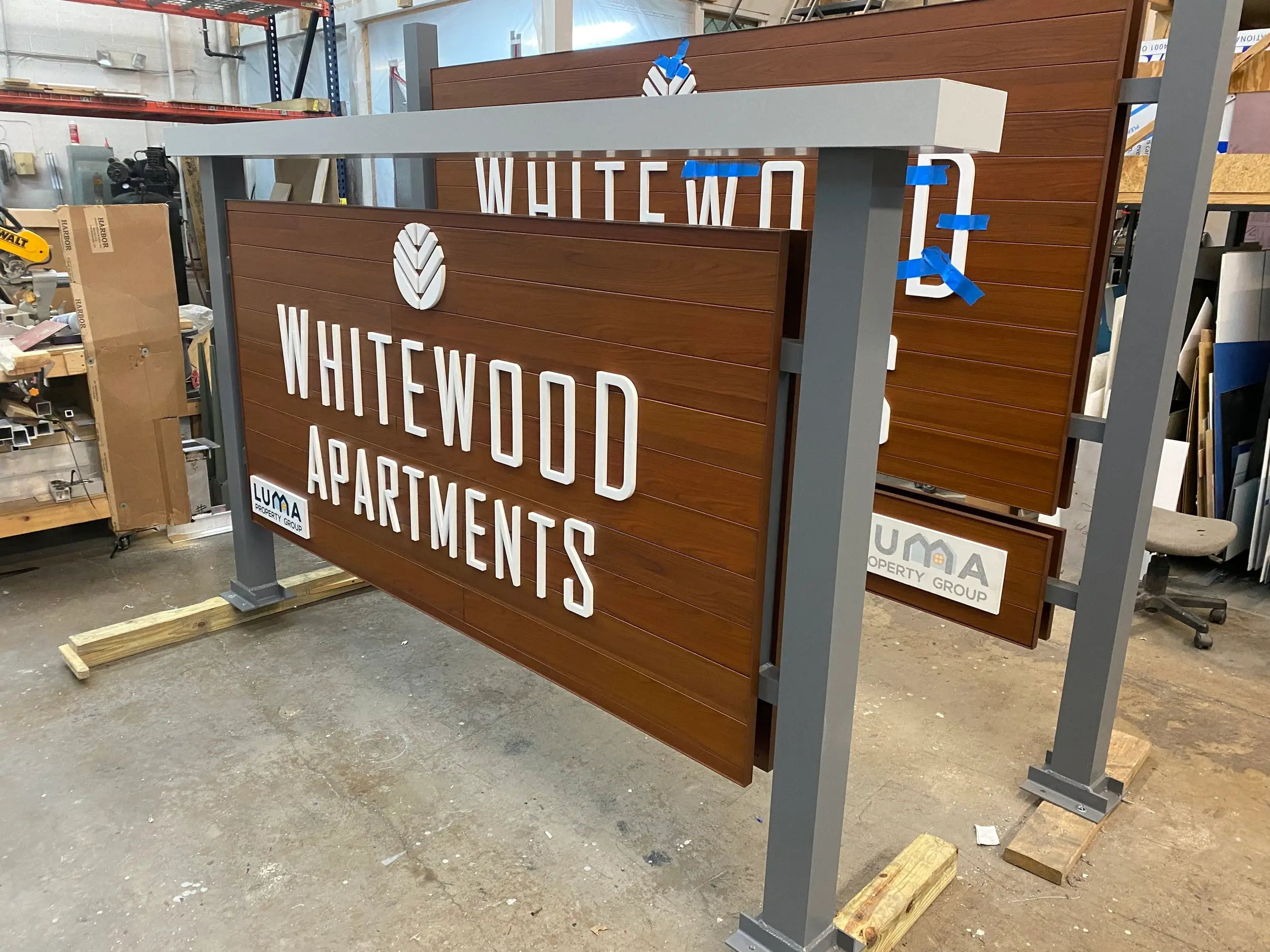 Whitewood Apartments sign panels in AFX woodgrain aluminum during fabrication
